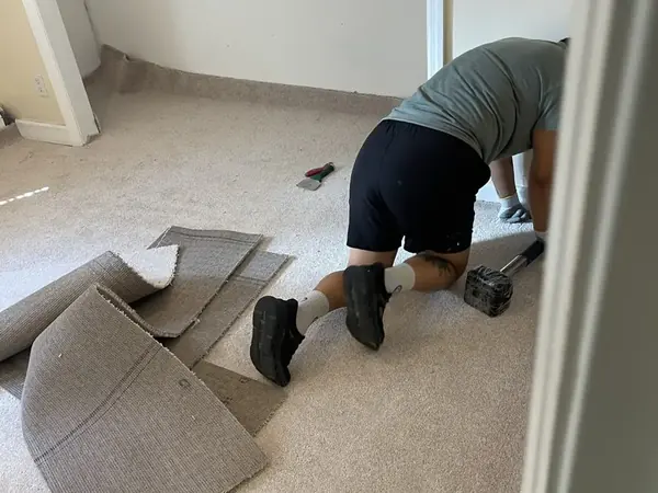 Wet carpet pulled up from a bedroom floor during a Queens water damage dry-out