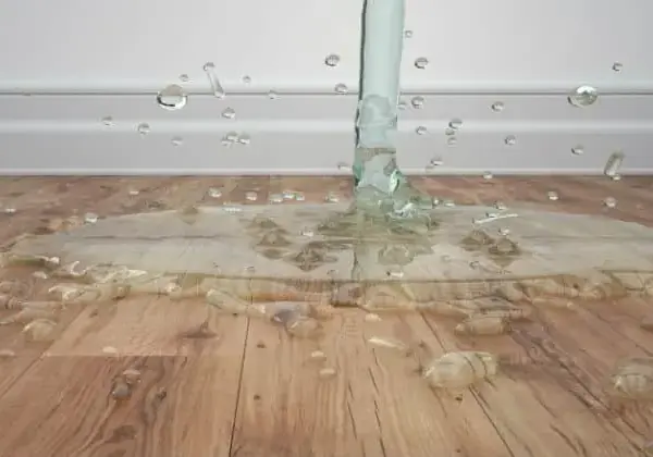 Water running onto a laminate floor from a failed supply hose in a Corona home