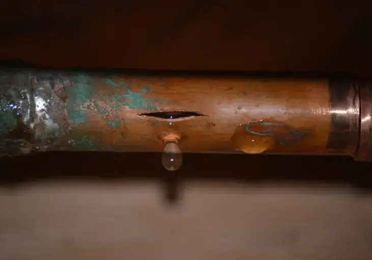 Split copper supply pipe dripping water in a Corona, NY home
