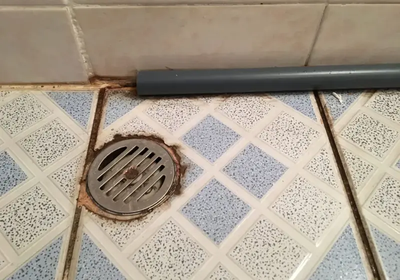 Basement floor drain on a tiled floor where sewer backups surface in Corona, NY