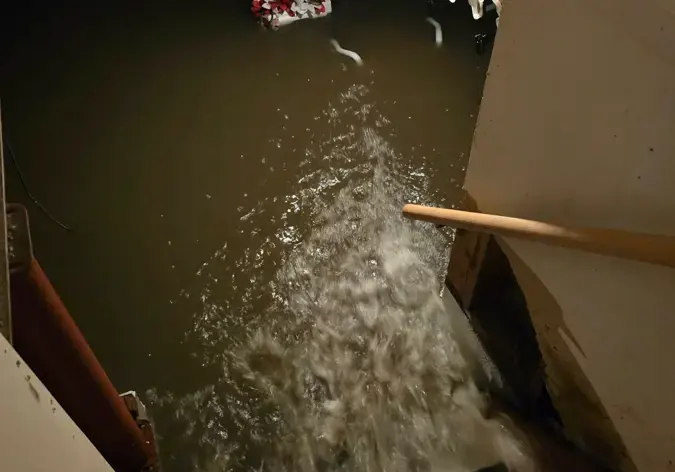Storm water pouring down basement stairs during a cloudburst in Queens