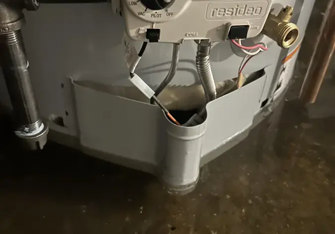 Gas water heater standing in water in a Corona, NY cellar